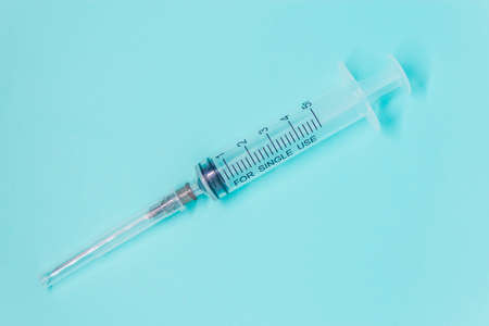 transparent medical syringe with needle protect on blue background close up layoutの写真素材
