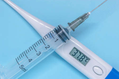 injection syringe and thermometer showing high temperature lying crosswise. High quality photoの写真素材