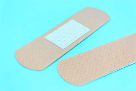 skin color medicine adhesive healing bandage layout on blue background. medical aid patch conceptの写真素材