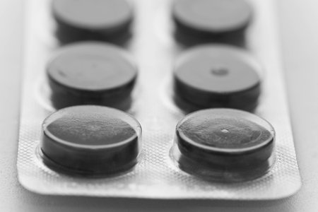 Medicine concepts. Macro picture of black tablets in the plateの写真素材