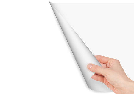 Hand opens a paper page on white backgroundの写真素材