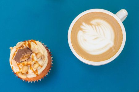 Caramel nut cupcake and cup of coffee on table. Top view.の写真素材