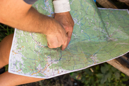 A woman planning a trip sitting with a map on her kneesの写真素材