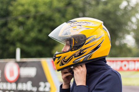 active man in yellow helmet competing on racing cars at kart circuit