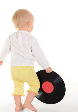baby playing with old vinyl record on white backgroundの写真素材
