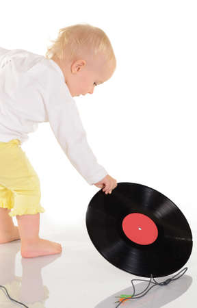 baby playing with old vinyl record on white backgroundの写真素材