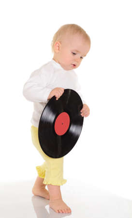 baby playing with old vinyl record on white backgroundの写真素材