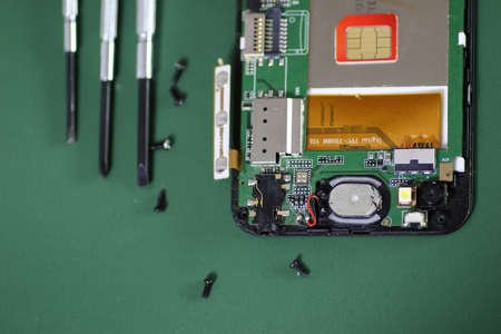 cell phone chip micro repair on green backgroundの写真素材