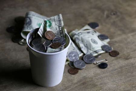 begging coin money on dirty wooden tableの写真素材