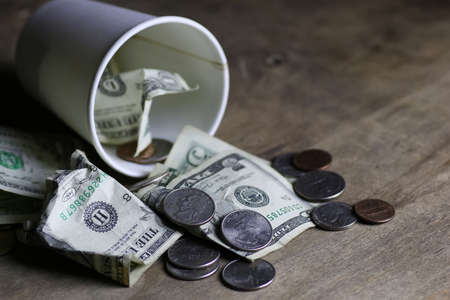 begging coin money on dirty wooden tableの写真素材