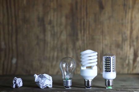 light bulbs and crumpled paper on a wooden backgroundの写真素材