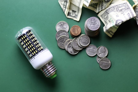 light bulb and money  on a green table