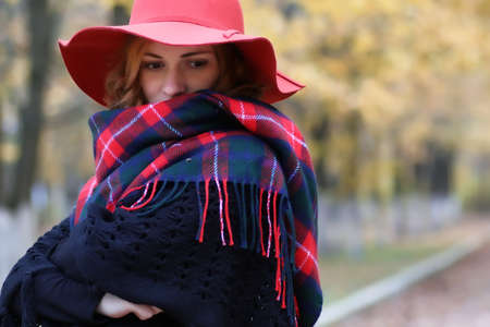 Serious woman wearing  red hat in autumn parkの写真素材