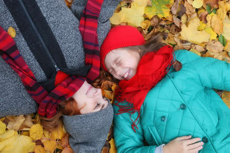 daughter and mother laying on a groundの写真素材