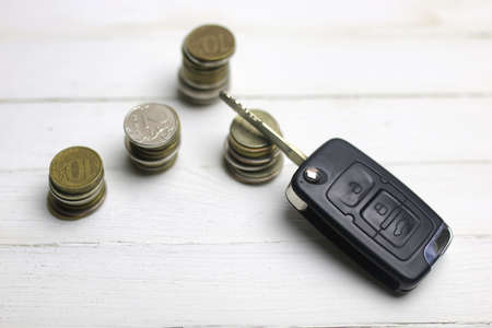 car key and coin on white wooden backgroundの写真素材