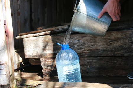 draw water from the well in plastic jarの写真素材