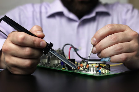 man hands chip soldering tools on a black background