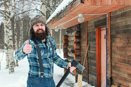 beard man in winter with axe outdoorの写真素材