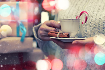 cup in a hand and stack giftsの写真素材