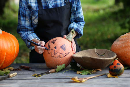 person hands carve pumpkin for Halloweenの写真素材