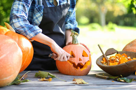 person hands carve pumpkins for Halloween holidayの写真素材
