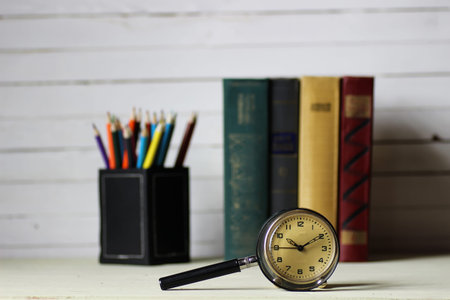 old book and retro watch on white wooden table