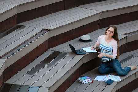 pretty female student outdoor in autumn seasonの写真素材