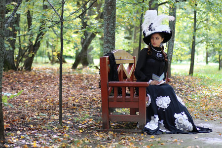 girl in retro dress past century read letter on the bench