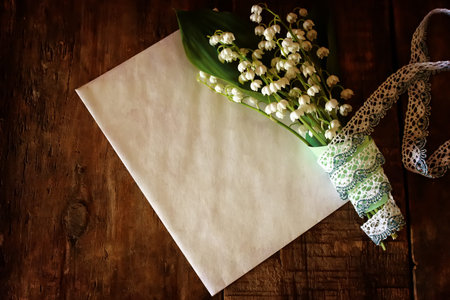 vintage effect on photo bouquet of lilies of the valley and space text