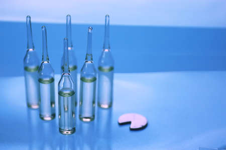 transparent vials of medicine on blue backgroundの写真素材