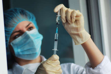 nurse hands holding syringe and medicine ampouleの写真素材