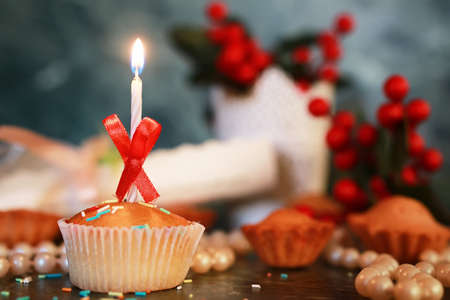 birthday cupcake with a candle on table bokehの写真素材