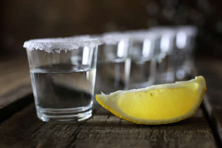 stack of tequila with salt and lemon on a wooden backgroundの写真素材