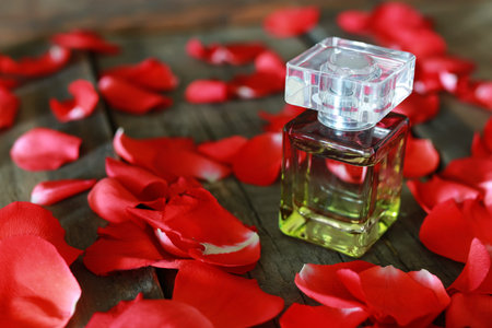 perfume bottle and petals of rose on a tableの写真素材