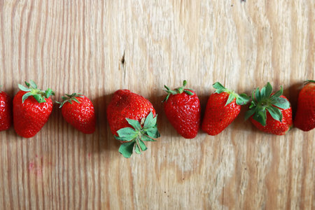 strawberries in a line  on wooden background