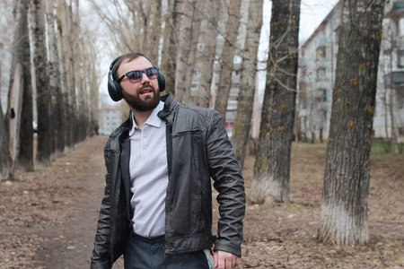 man with beard and headphones in the parkの写真素材
