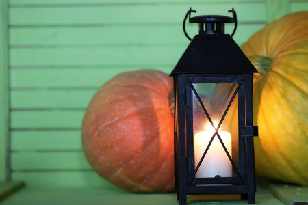 pumpkin and lamp on green wooden tableの写真素材