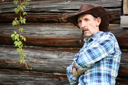 cowboy old man smoke pipe on village outdoor
