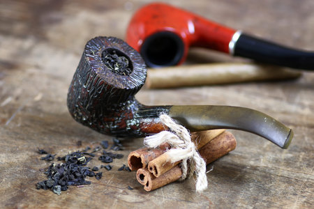 brown pipe and tobacco on the table wooden