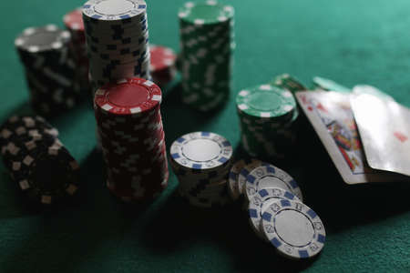 Poker chips and cards on the green clothの写真素材