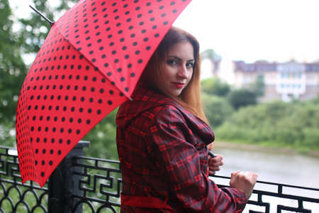 woman in a raincoat with an umbrella outdoorの写真素材