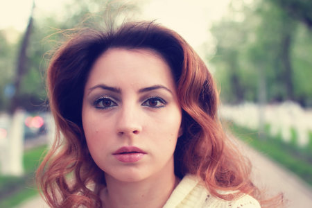 portrait of a happy young girl of European appearance with warm spring sunny dayの写真素材