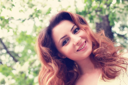 portrait of a happy young girl of European appearance with warm spring sunny dayの写真素材