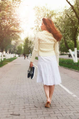 portrait of a happy young girl of European appearance with warm spring sunny dayの写真素材