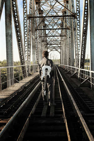 a young man in a leather biker jacket with electric guitar on the street in spring dayの写真素材