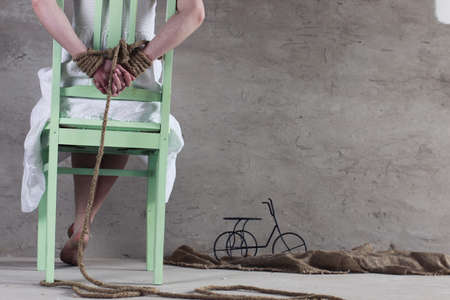Portrait of a young red-haired girl on a background of gray plaster wallの写真素材