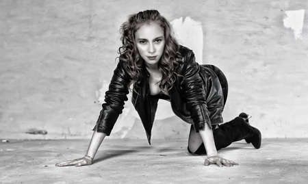 Portrait of a young red-haired girl on a background of gray plaster wallの写真素材
