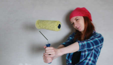 Portrait of a young red-haired girl on a background of gray plaster wallの写真素材