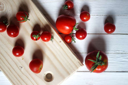 fresh small red cherry tomatoes on a white wooden backgroundの写真素材