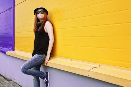 Portrait of a cute girl hipster on the background wall color Supermarket